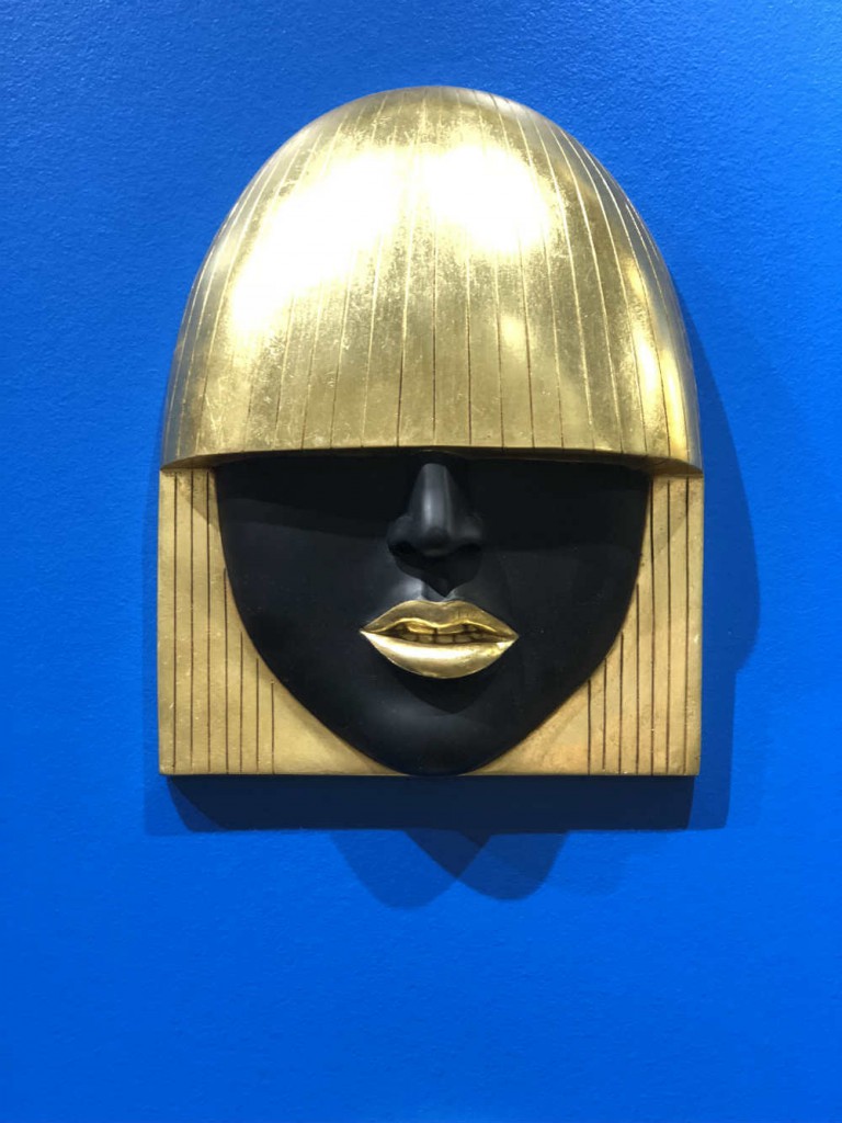 Masks are always cool but the gold and black glamour of this one is particularly stunning on a bright blue wall.